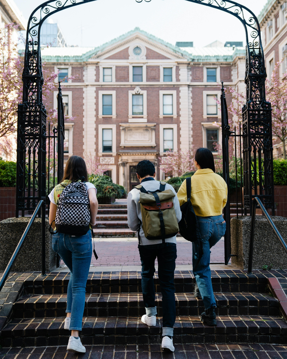 A photo of three students entering a university campus